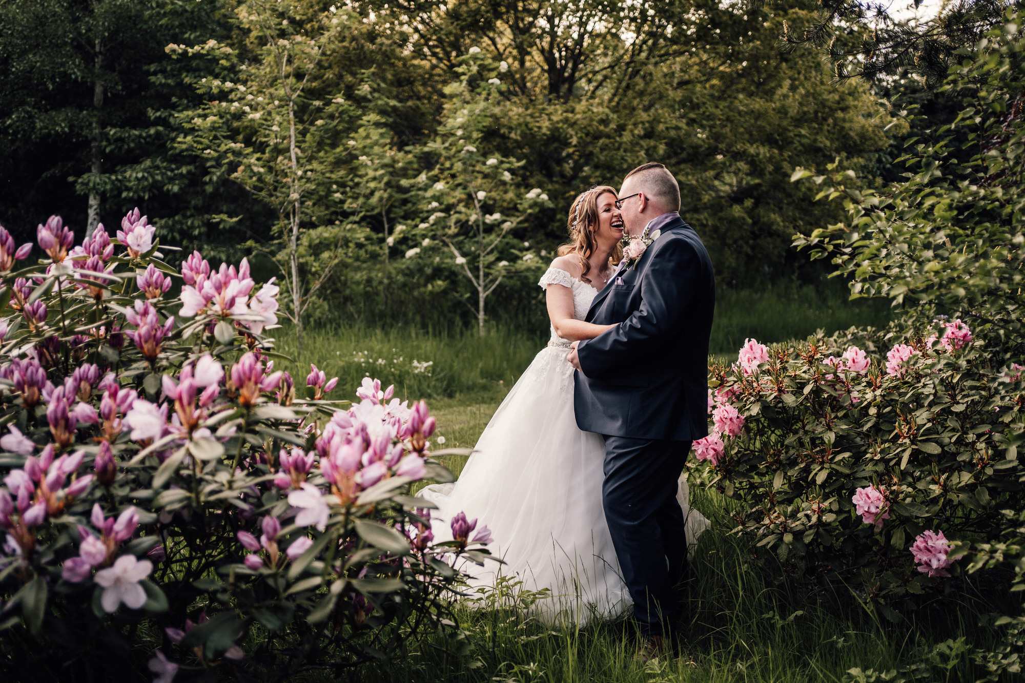 spring seasonal wedding photography of bride and groom among pink blooming flowers