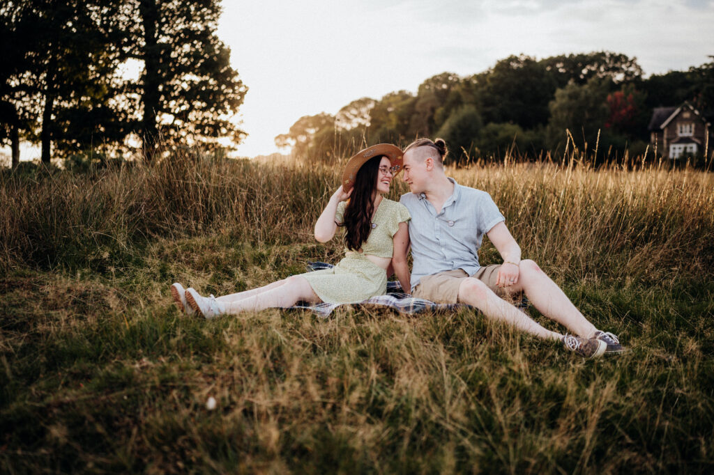 Couple sitting in grass together on engagement session 